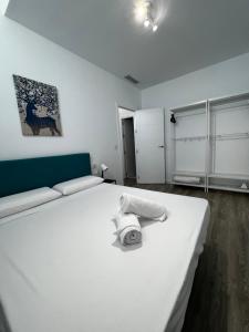 a bedroom with a white bed with towels on it at Los Almendros - Free Parking in Córdoba