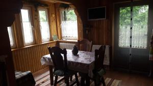 a dining room with a table and chairs and windows at Pryvitannya Sontsyu in Skhidnitsa