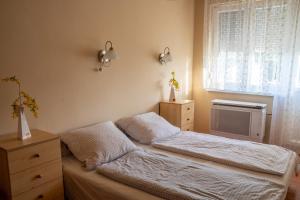 ハイドゥソボスローにあるPávai Apartmanの小さなベッドルーム(ベッド1台、窓付)