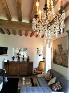 a living room with a chandelier hanging from the ceiling at Vue sur Chateau et Loire in Saumur