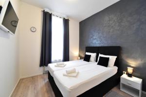 1 dormitorio con 1 cama grande con sábanas blancas en Virtus Apartments and Rooms with Free Private Parking en Zagreb