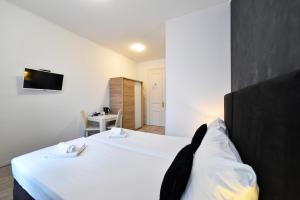 a bedroom with a bed and a tv on the wall at Virtus Apartments and Rooms with Free Private Parking in Zagreb