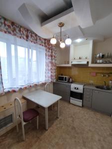 a kitchen with a table and a table and chairs at X,ata in Almaty