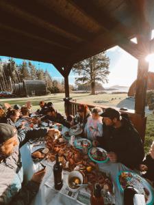 un grupo de personas sentadas alrededor de una mesa comiendo comida en Ocean Village Resort en Tofino