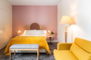 um quarto de hotel com uma cama e um sofá em Casas De Adriano em Sevilha