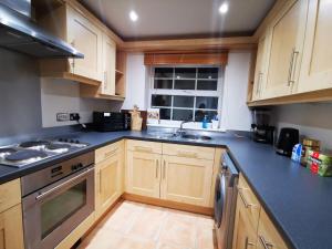 a kitchen with wooden cabinets and a sink and a window at Gorgeous apartment + attentive host + free parking in York