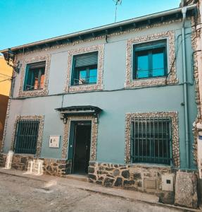 a blue building with two windows and a door at La Granja Villa in La Granja de San Ildefonso