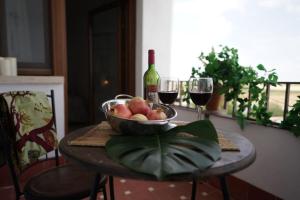 a table with a bowl of fruit and two glasses of wine at Casa Rural Horizontes de la Mancha in El Toboso