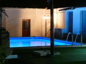 a swimming pool in a building with a blue light at Casa Rural Horizontes de la Mancha in El Toboso