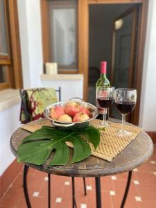 a table with a bowl of fruit and two glasses of wine at Casa Rural Horizontes de la Mancha in El Toboso