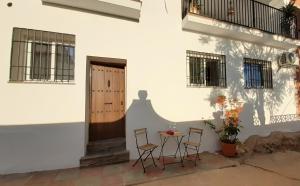 patio ze stołem i krzesłami przed budynkiem w obiekcie Apartamento Alegría w mieście Frigiliana