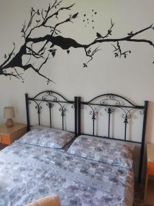 - une chambre avec un lit orné d'une fresque murale sur les arbres dans l'établissement Il Girasole, à Crotone