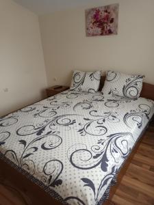 uma cama com um edredão e almofadas preto e branco em Guest rooms Bansko em Bansko