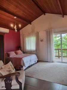 a bedroom with a bed and a large window at Pouso Mantiqueira in Cunha