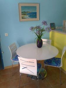 una mesa blanca y sillas con un jarrón de flores. en Apartments Miriam Karol, en Rukavac