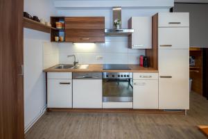 kuchnia z białymi szafkami i zlewem w obiekcie Apartment-Alpenfantasie w mieście Zell am See