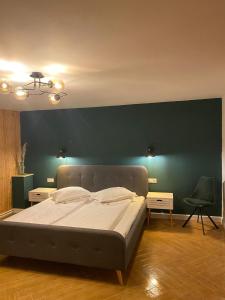 a bedroom with a large bed and a green wall at Cabana Kodru in Vatra Dornei