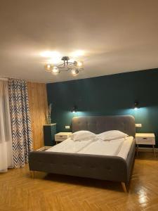 a large bed in a room with a green wall at Cabana Kodru in Vatra Dornei