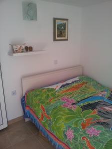 a bedroom with a bed with a colorful comforter at Apartments Miriam Karol in Rukavac