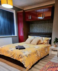 a bedroom with a bed with a yellow comforter at 4 bedroom House Coventry Sleep 9 + 3Parking spaces in Coundon