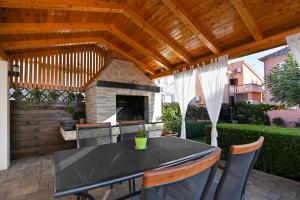 a patio with a table and a fireplace at Apartment Irena in Posedarje