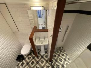 a small bathroom with a sink and a toilet at Élégant studio avec mezzanine porte des Ternes in Paris