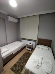 a small room with two beds and a window at M.H.T in Edirne