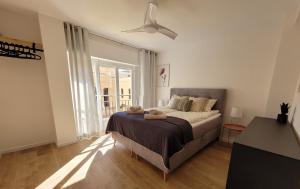 een slaapkamer met een bed en een groot raam bij Holidays near the beach in Alicante