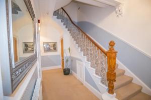 a staircase in a home with blue and white walls at Granite City Guest House in Aberdeen