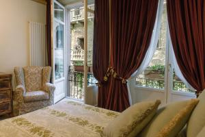 a bedroom with a bed and a window and a chair at La Corte Di Giulietta in Verona