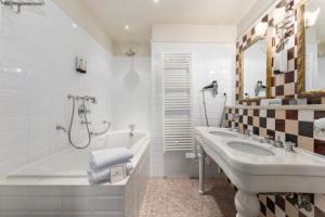 La salle de bains blanche est pourvue d'une baignoire, d'un lavabo et d'une baignoire. dans l'établissement Canal Suites, à Bruges