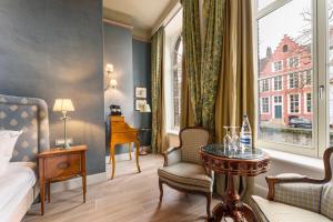 a hotel room with a bed and a table and a window at Canal Suites in Bruges