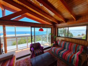 a living room with a couch and a view of the ocean at Espectacular Casa Tres Pisos, cap. 21 Personas. in Algarrobo