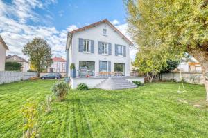 a large white house with a yard with grass at Villa Saint-Mard - King Size bed - 10min Aéroport CDG 25min Paris by train in Saint-Mard
