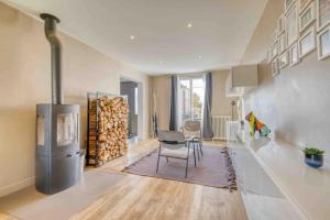 a living room with a table and a pile of logs at Villa Saint-Mard - King Size bed - 10min Aéroport CDG 25min Paris by train in Saint-Mard