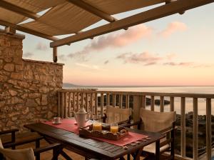 a table on a balcony with a view of the ocean at Orfos Villas in Agios Nikolaos