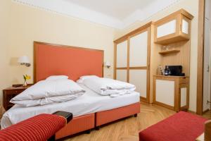 ein Schlafzimmer mit einem großen Bett mit einem orangefarbenen Kopfteil in der Unterkunft Hotel Herzoghof in Baden