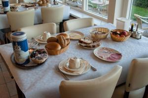 une table avec des assiettes et des bols de nourriture dans l'établissement Hotel Bos en Duinzicht, à Nes