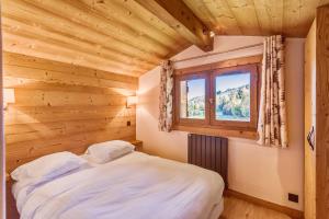 a bedroom with a bed and a window at Wonderful appartement in a chalet with balcony - Megève - Welkeys in Megève