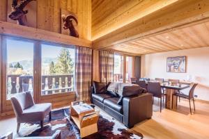 a living room with a leather couch and a table and chairs at Wonderful appartement in a chalet with balcony - Megève - Welkeys in Megève