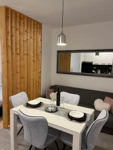 a dining room with a white table and chairs at Studio apartman Implex in Đakovo