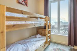 1 Schlafzimmer mit 2 Etagenbetten und einem Fenster in der Unterkunft Cosy apartment in the center of Chamonix - Welkeys in Chamonix-Mont-Blanc