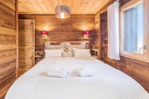 a bedroom with a large bed with towels on it at Le Hameau des Cimes - Welkeys in Megève