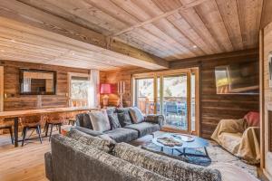 a living room with two couches and a table at Le Hameau des Cimes - Welkeys in Megève