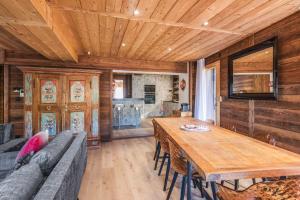 a dining room with a table and a wooden ceiling at Le Hameau des Cimes - Welkeys in Megève