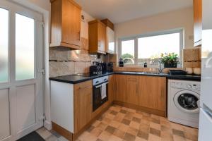 a kitchen with a sink and a dishwasher at 3 Bedroom Home l Free Parking l Long and Short Term Stays in Wigan