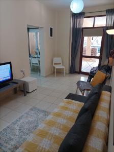 een woonkamer met een bank en een tv bij Happy holiday apartment in Artemida