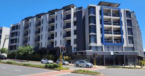 a large building with cars parked in front of it at Urban Park Apartment in Durban