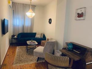 ein Wohnzimmer mit einem blauen Sofa und einem Tisch in der Unterkunft Svolio Welcome in Thessaloniki