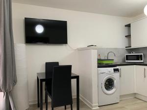 een keuken met een tafel en een wasmachine bij 42 NELSON ST in Largs +4 foto's